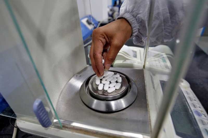 A pharmacist checks weight of Paracetamol, a common pain reliever also sold as acetaminophen, tablets inside a lab of a pharmaceutical company on the outskirts of Ahmedabad