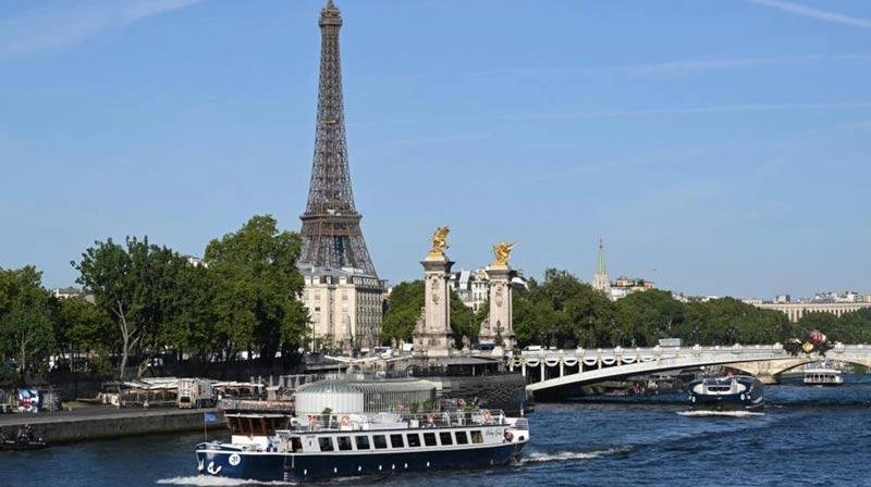 Boats parade past the Eiffel Tower in a rehearsal of the Paris Olympics opening ceremony on the river Seine