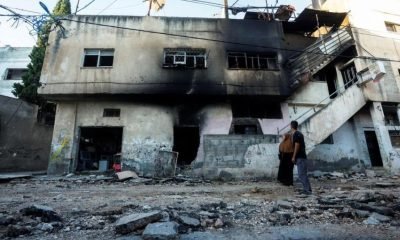 Palestinians look at a damaged building, after the Israeli army's withdrawal from the Jenin camp