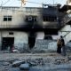 Palestinians look at a damaged building, after the Israeli army's withdrawal from the Jenin camp