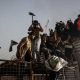 Protesters climb a fence as they gather near the Swedish embassy in Baghdad hours after the embassy was stormed and set on fire ahead of an expected Koran burning in Stockholm, in Baghdad, Iraq, July 20, 2023.