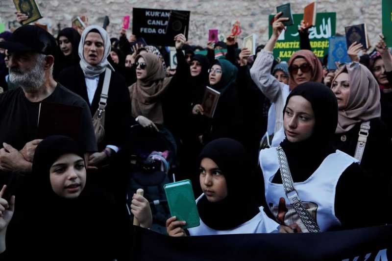 Protesters hold copies of the Koran as they demonstrate outside the Consulate General of Sweden in Istanbul