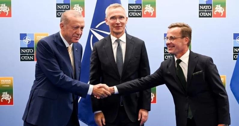 Turkish President Recep Tayyip Erdogan and Swedish Prime Minister Ulf Kristersson shake hands with Nato chief Jens Stoltenberg looking on