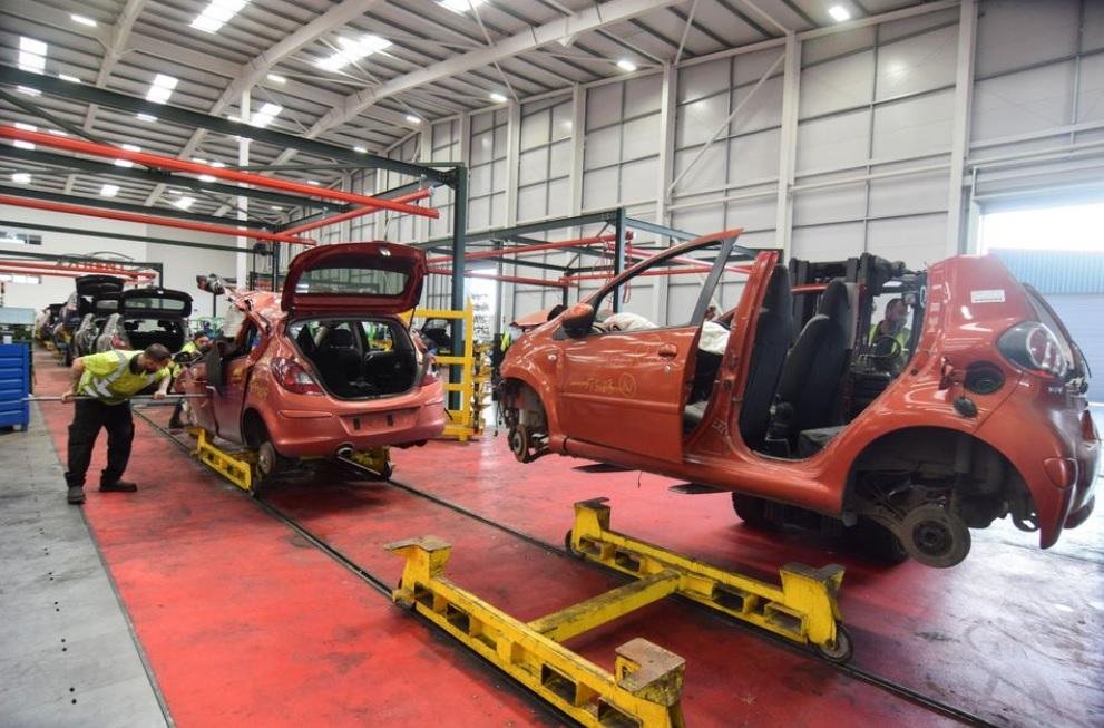 Workers at the vehicle dismantler company Charles Trent Ltd take apart a wrecked vehicle for materials and parts to reuse or recycle