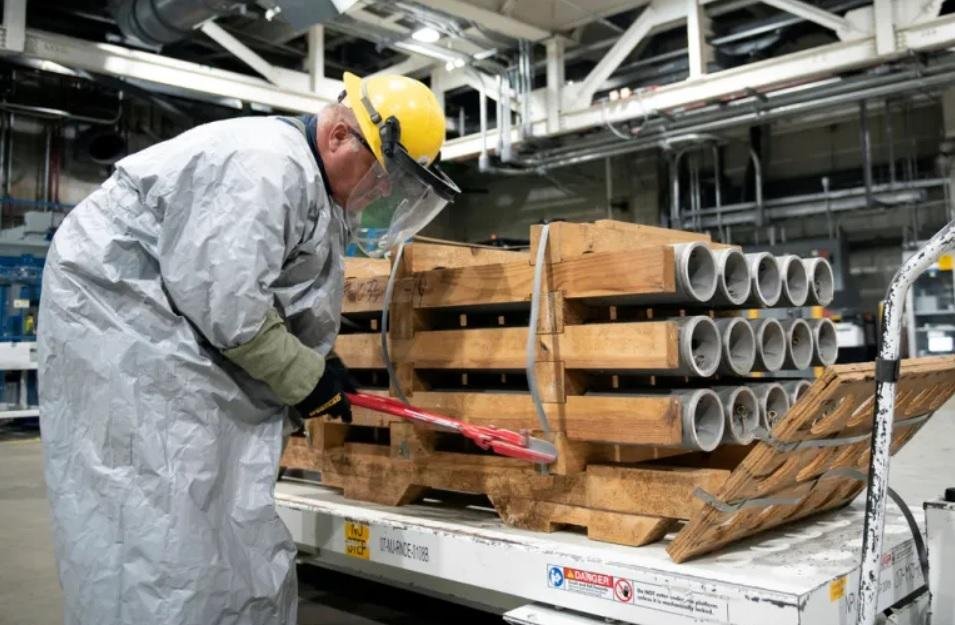 operator cuts the metal bands on a pallet of M55 rockets containing GB nerve agent