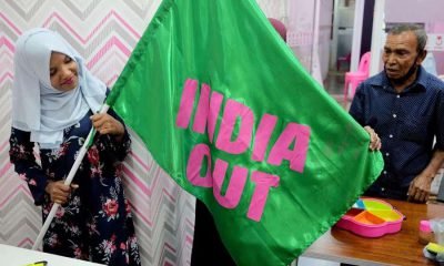 A Progressive Party of Maldives worker poses with an "India Out" flag in Male, Maldives