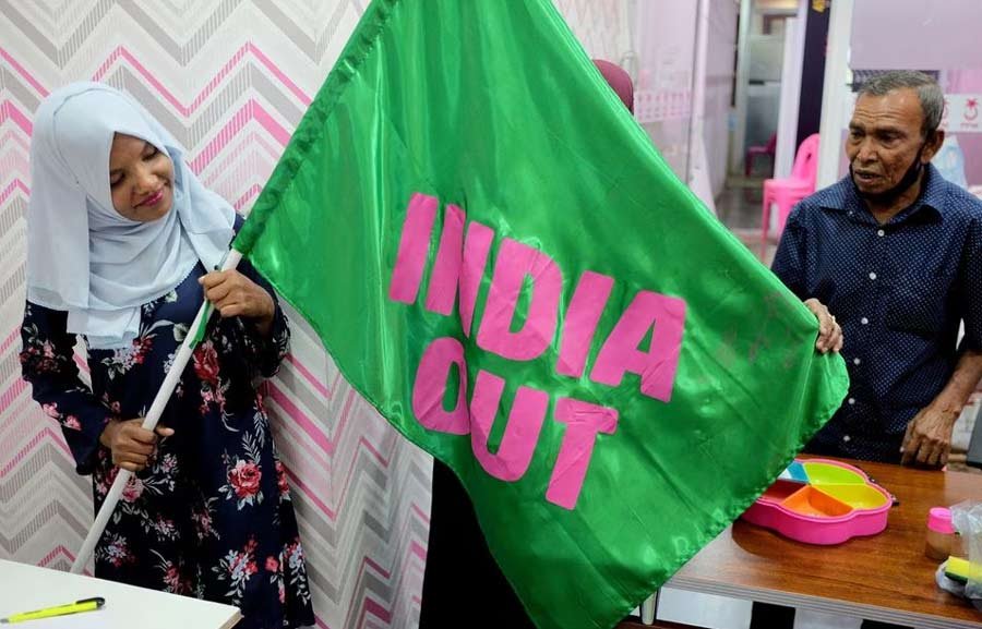 A Progressive Party of Maldives worker poses with an "India Out" flag in Male, Maldives