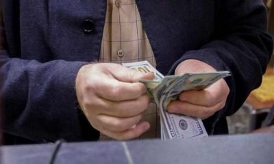 A man counts U.S. dollars at a currency exchange shop in Baghdad,