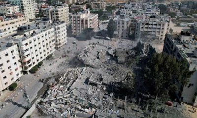 Palestinians gather around residential buildings destroyed in Israeli strikes in Zahra City, amid the ongoing conflict between Israel and Palestinian Islamist group Hamas, in southern Gaza City, October 19, 2023