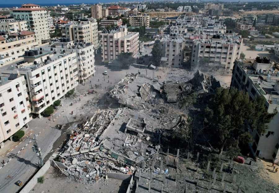 Palestinians gather around residential buildings destroyed in Israeli strikes in Zahra City, amid the ongoing conflict between Israel and Palestinian Islamist group Hamas, in southern Gaza City, October 19, 2023