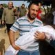 A mourner carries the body of a child, during the funeral of Palestinians from al-Astal family, who were killed in Israeli strikes, in Khan Younis in the southern Gaza Strip, October 22, 2023