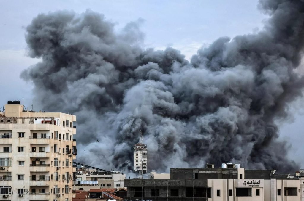 plume of smoke rises above buildings in Gaza City