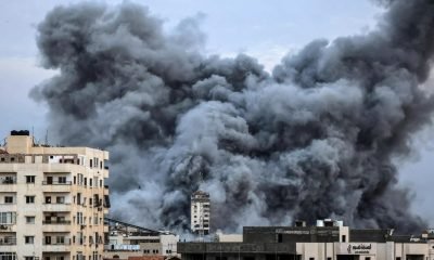 plume of smoke rises above buildings in Gaza City