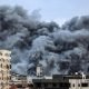 plume of smoke rises above buildings in Gaza City