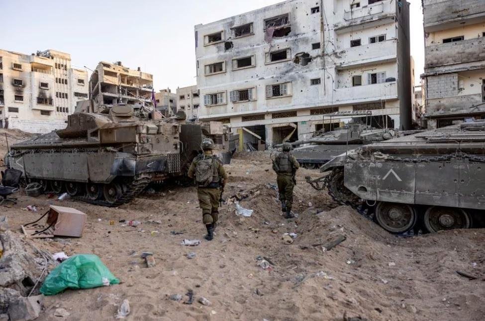 Israeli soldiers walk through rubble, amid the ongoing ground invasion against Palestinian Islamist group Hamas in the northern Gaza Strip, November 8, 2023