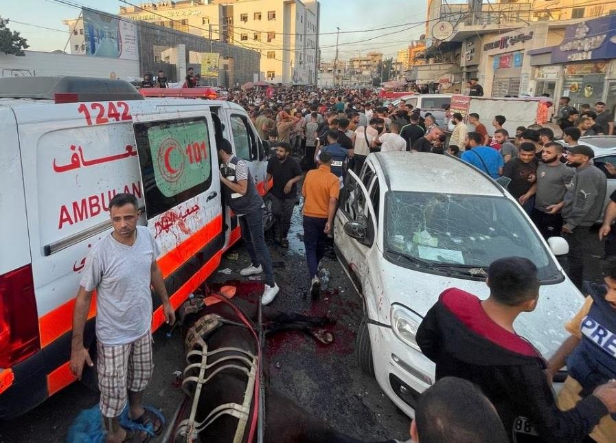 Palestinians check the damages after a convoy of ambulances was hit, at the entrance of Shifa hospital in Gaza City, November 3, 2023.