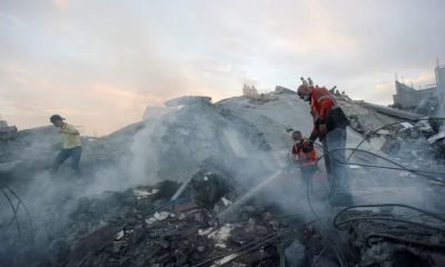 Palestinians conduct search and rescue operations at the site of Israeli strikes on a residential building